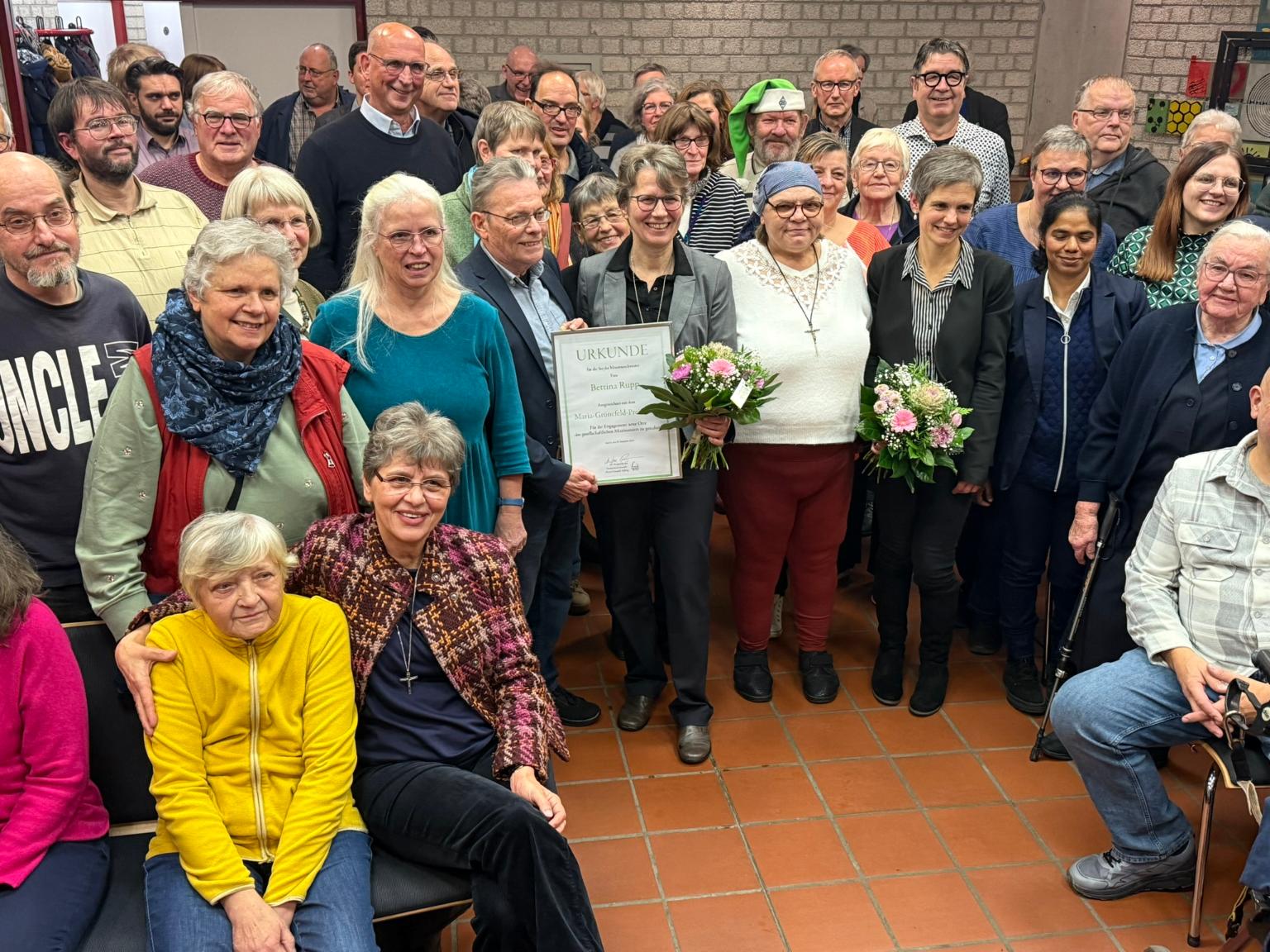 Bezeichnender Schlussakkord eines Abends im Zeichen des Zusammenhalts: Sr. Bettina Rupp in der Mitte der Gäste. (c) thh